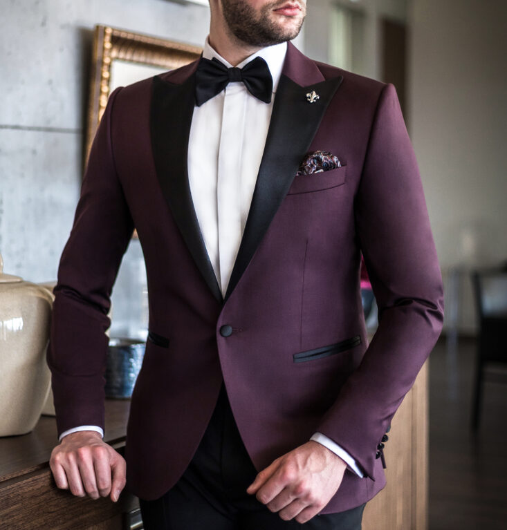 Modèle mariage homme dans un costume sur mesure de couleur lit de vin / bordeaux et nœud papillon