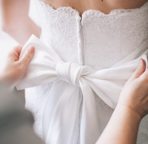 Big,Bow,On,A,Wedding,Dress,In,Hands,Close,Up.